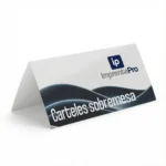 Carteles de sobremesa para eventos promocionales triangular, mostrando el logotipo de Imprenta pro en el centro y un patrón decorativo en la parte inferior. Ideal para uso en mesas y mostradores.