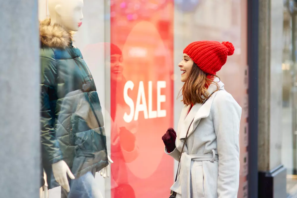 Vinilos adhesivos para escaparate rojo instalado sobre el cristal de un escaparate en la calle, mostrando su versatilidad para personalizar superficies como escaparates o automóviles.